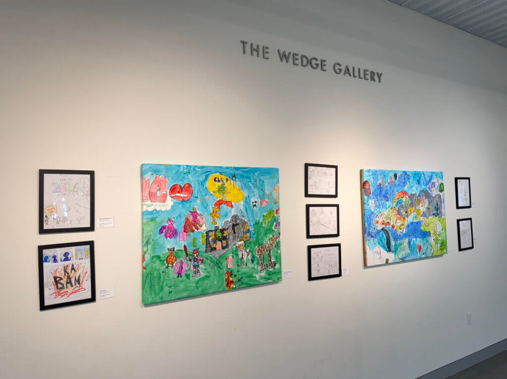 The exhibit includes paintings by children ages 5 to 8, comic drawings by students ages 8 to 12, and observational drawings by teenagers. Photo by Katie Baum