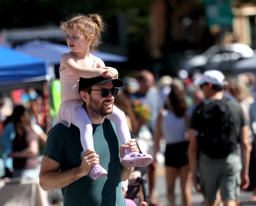 Riley Mara, 3, of Acton, surveys Main Street from her perch atop the shoulders of her father, Patrick Mara.

