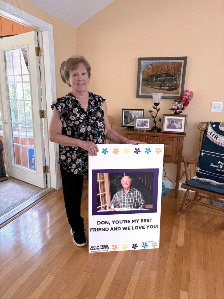 Nancy Gresham stands with a poster of her husband from the Walk To End Alzheimer’s. Photo: Christine M. Quirk/The Acton Bridge