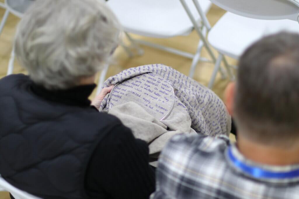 Merill Comeau embroiders her father's memoir during the hourslong proceedings. Photo: Trace Salzbrenner/The Acton Bridge