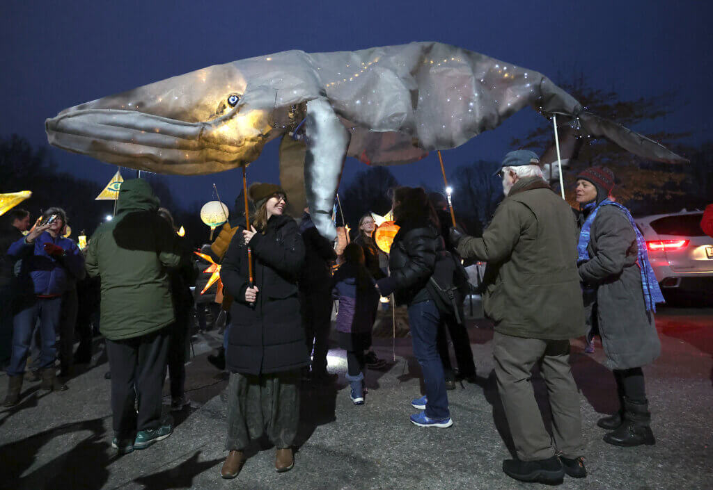 Paradegoers carry aloft an illuminated whale lantern created by Acton artist CC King of the Musketaquid Arts & Environment program. 
