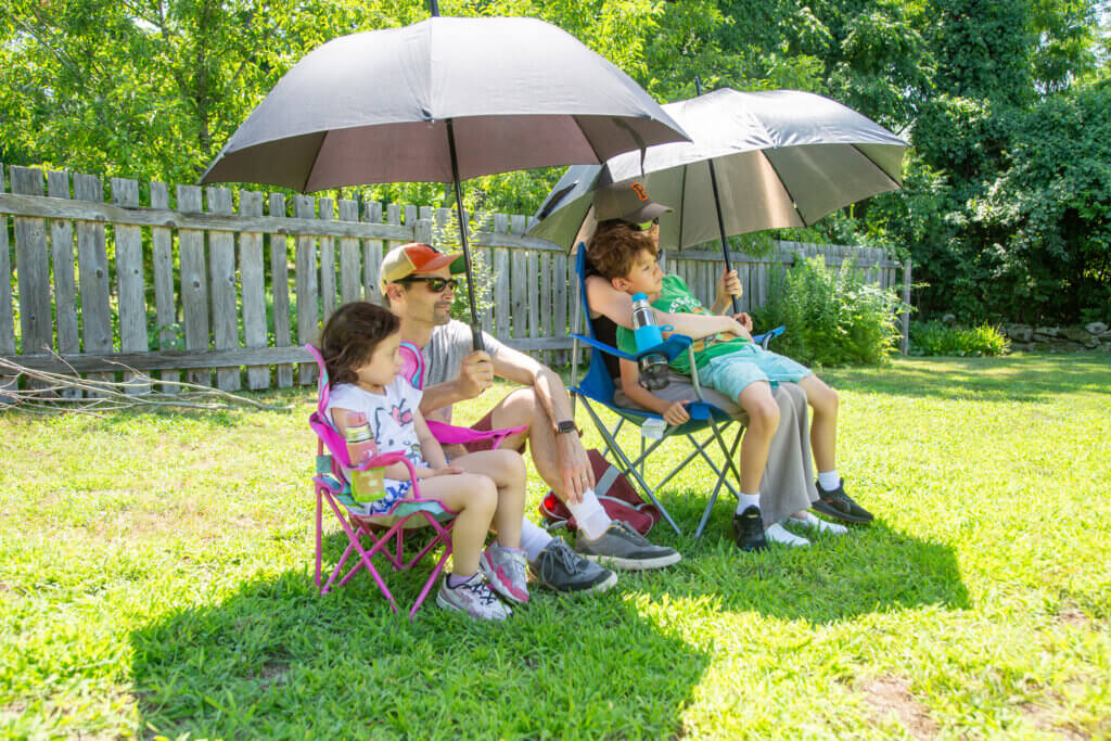 Miles Miller and Karen Jeng Miller sheltered their children, Mara, 4, and Miles, 7, from the beating sun.
