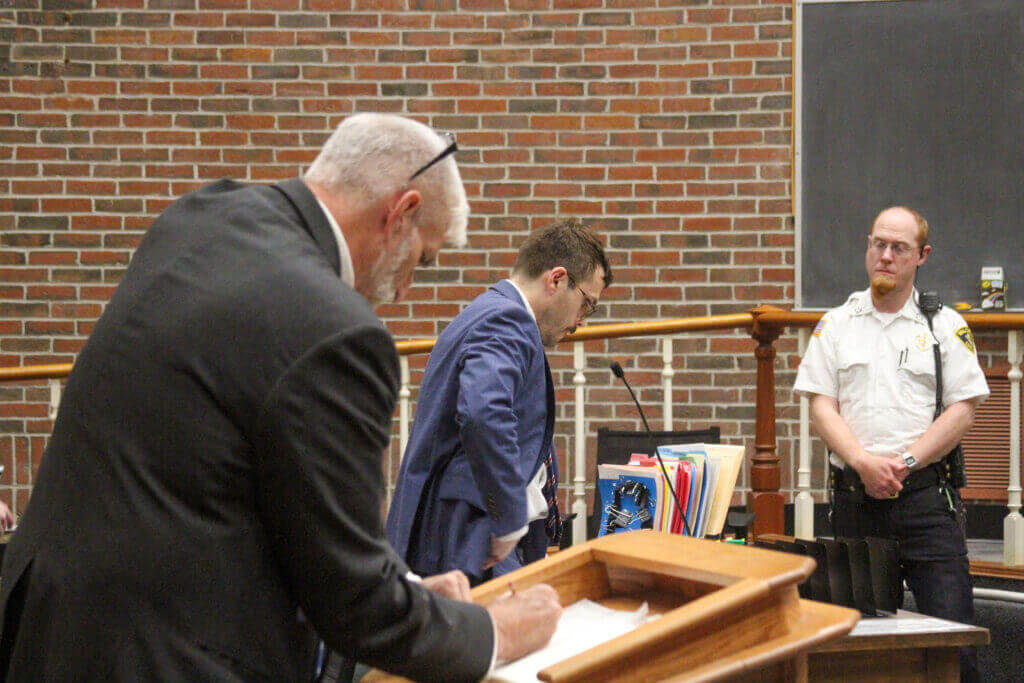 Acton resident John Grace, left, and Assistant District Attorney Nick Martin, center, prepare for a September 21 hearing while a court officer looks on. Photo: Dakota Antelman/The Acton Bridge