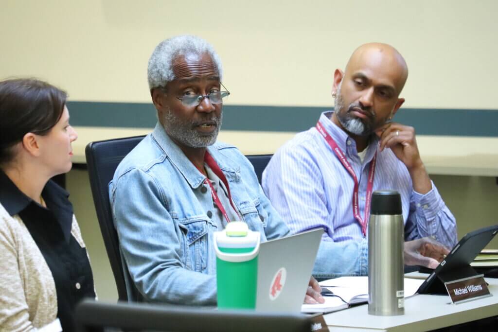 Michael Williams, center, makes his case for the chair’s role. Sandeep Pisharody, right, was elected chair of the K-8 committee. Photo: Trace Salzbrenner/The Acton Bridge