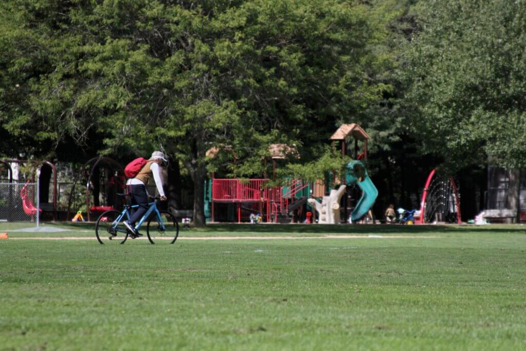 A cyclist rides across the grass at Rideout Park in West Acton. Photo: Dakota Antelman/The Acton Bridge