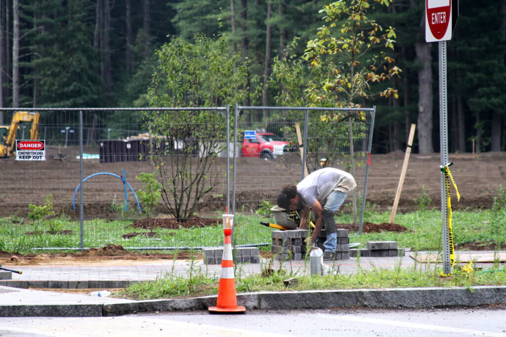 A worker picks up bricks on a CMS walkway near Old Marlboro Road. Photo: Dakota Antelman/The Acton Bridge