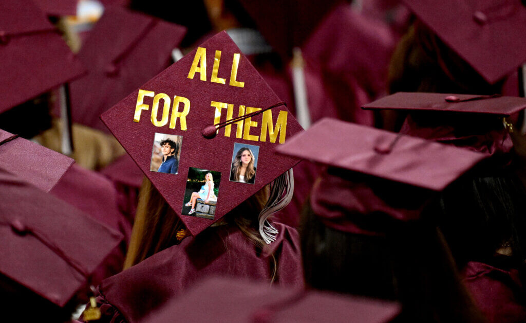 A student wears a mortarboard dedicated to late Acton-Carlisle seniors Jimmy McIntosh, Maisey O’Donnell, and Hannah Wasserman during graduation exercises on Saturday, May 31. Photo: Ken McGagh/The Acton Bridge