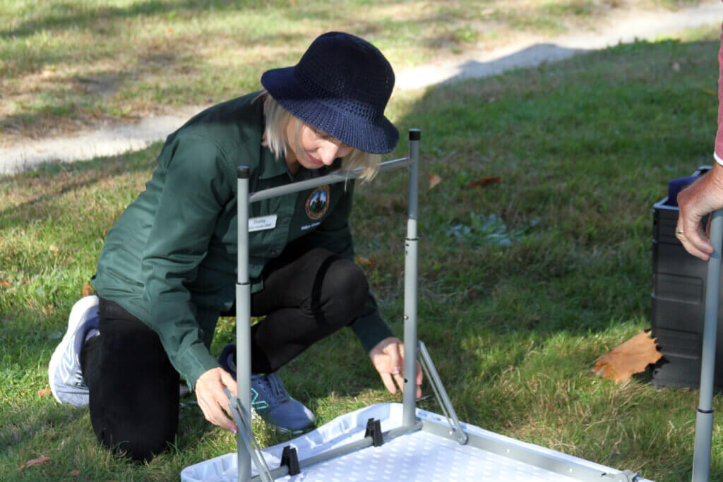 Town tour guide Shelley Belton helps break down a table after the first day of work at a pop-up visitor center at North Bridge during the ongoing federal government shutdown. Photo: Dakota Antelman/The Acton Bridge