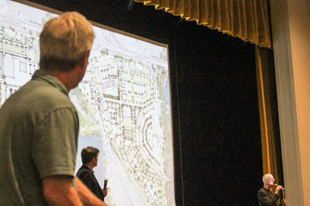 Alan Cathcart, left, looks at a draft plan showing how parking might wrap around a wastewater treatment plant at the shuttered MCI-Acton prison. Photo: Dakota Antelman/The Acton Bridge