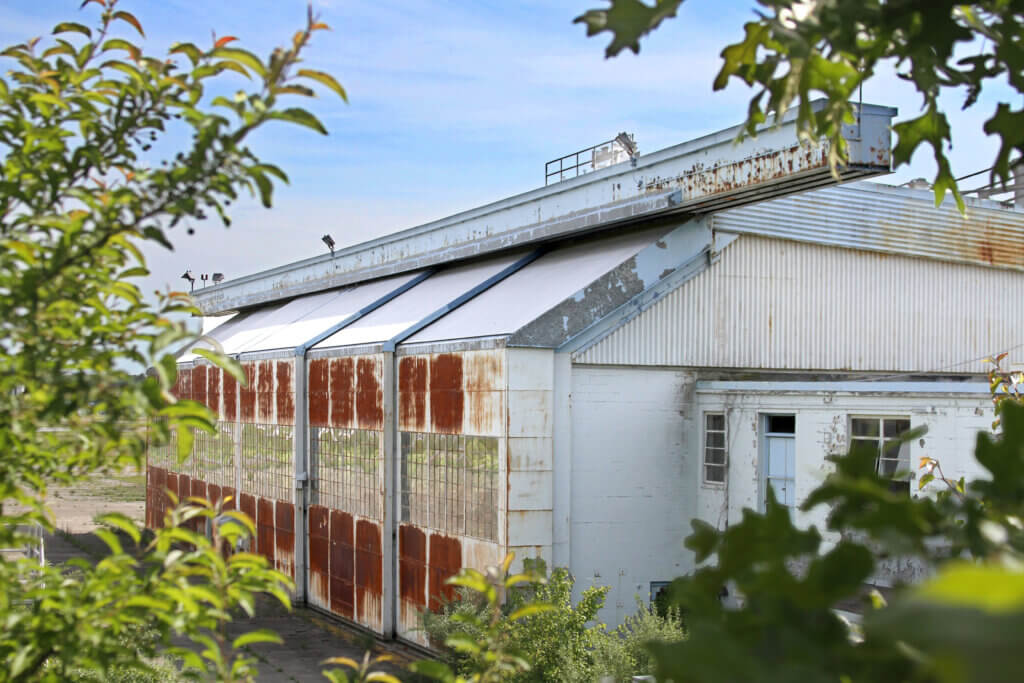 Developers hope to renovate the rusted old Navy hangar at Hanscom Field in time for Boston-based Merlin Labs to arrive next year. Photo: Dakota Antelman/The Acton Bridge