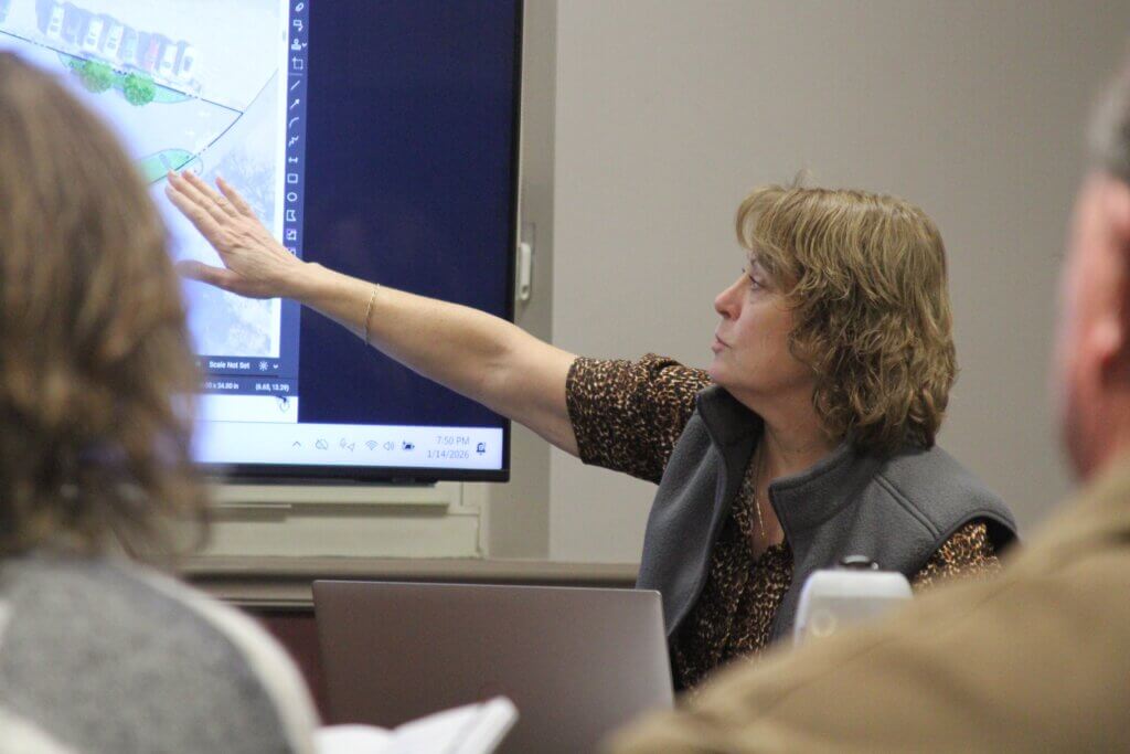 Town Planner Elizabeth Hughes gestures toward illustrations of a planned 166 Commonwealth Avenue redevelopment during a meeting of the West Acton Advisory Committee. Photo: Dakota Antelman/The Acton Bridge