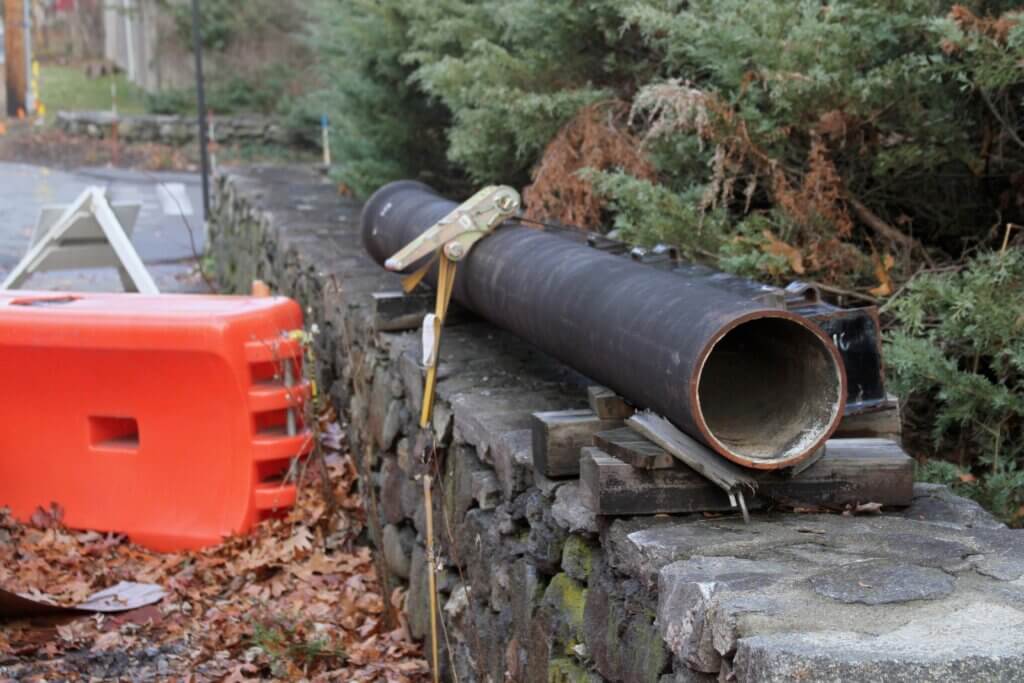 A pipe rests on a stone wall beside Acton Greene ahead of Baker Avenue culvert repair work. Photo: Dakota Antelman/The Acton Bridge