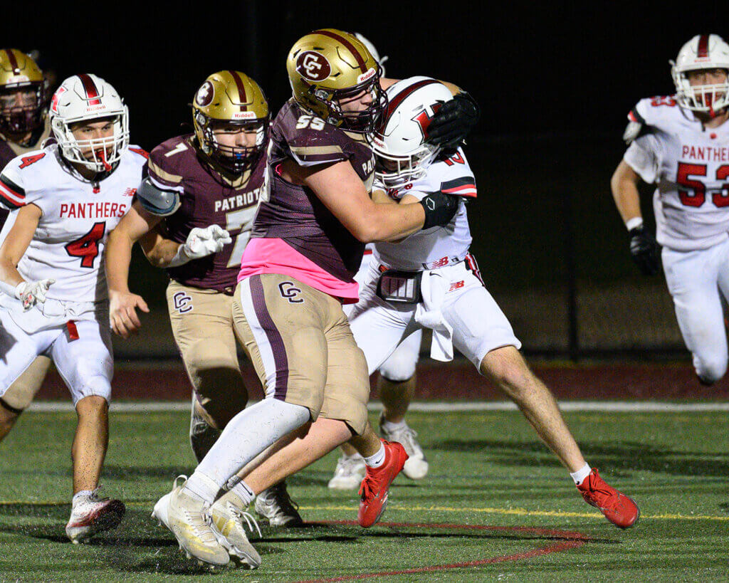 Patriots defensive lineman Eli Svatek (55) tackles Holliston quarterback Jack McDonald (15) in the end zone for a safety. Photo by Jon Straggas