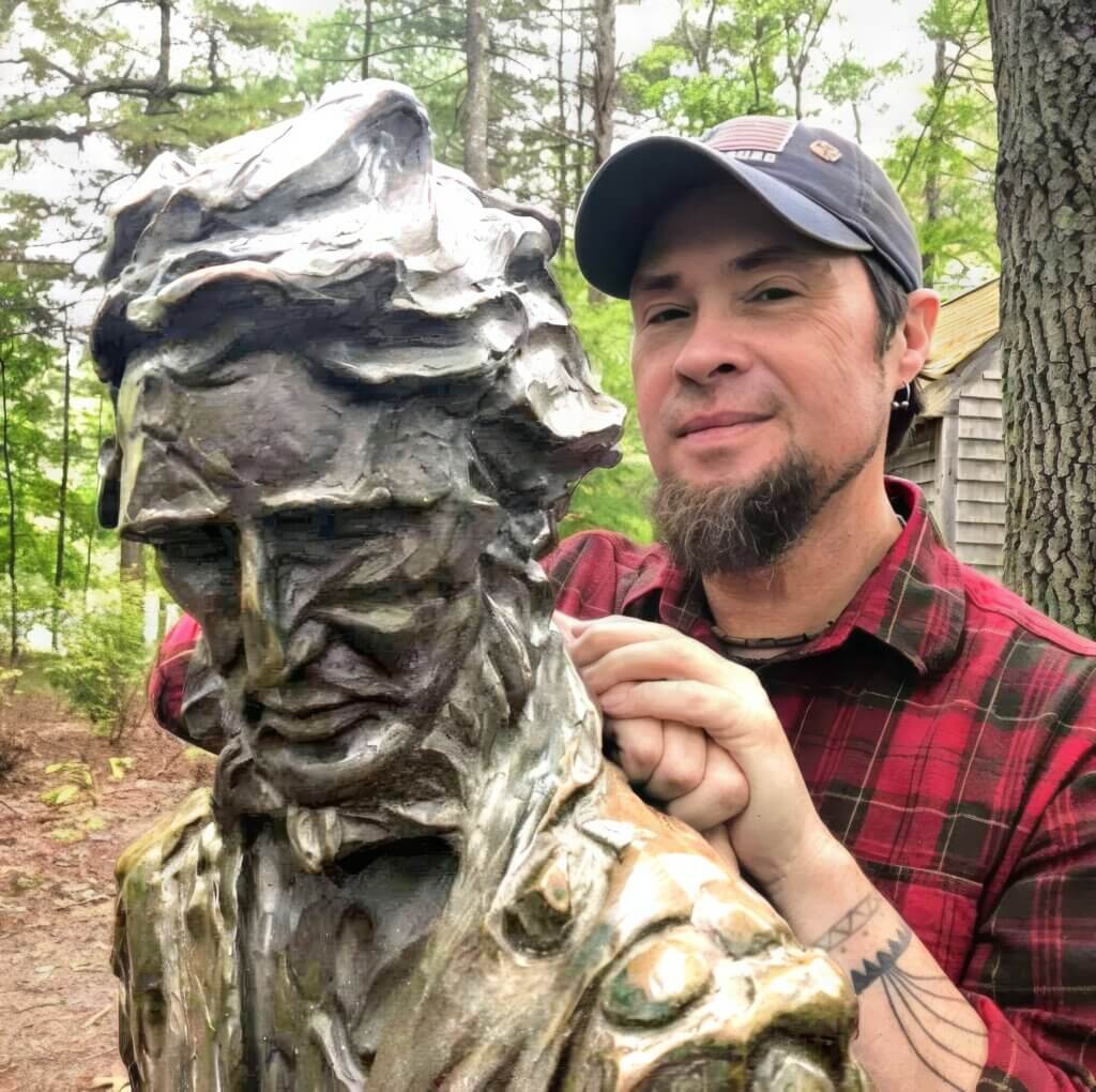 Richard Smith as himself next to a statue of Henry David Thoreau near the latter’s replica cabin at Walden Pond State Reservation. Courtesy photo