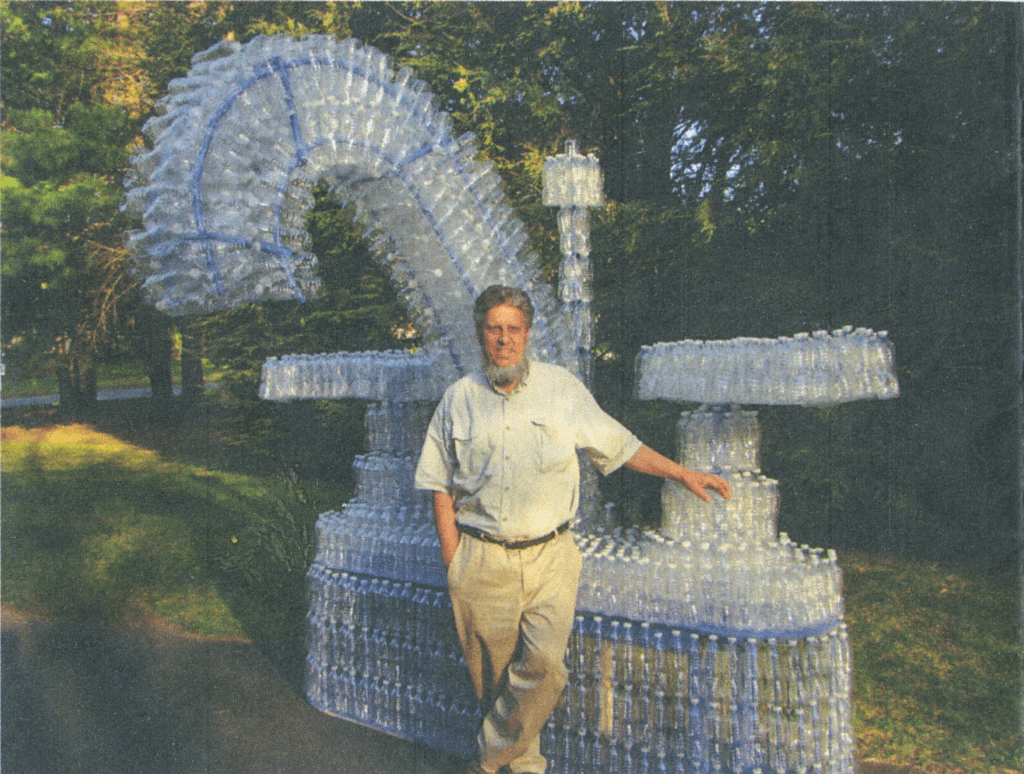 Lawson and the towering sculpture he created when Acton was considering a ban on plastic water bottles. Courtesy photo
