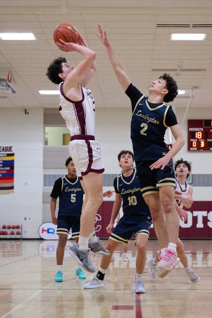 Matthew Logan shoots over Lexington’s Klei Alimadhi. Photo by Jon Straggas