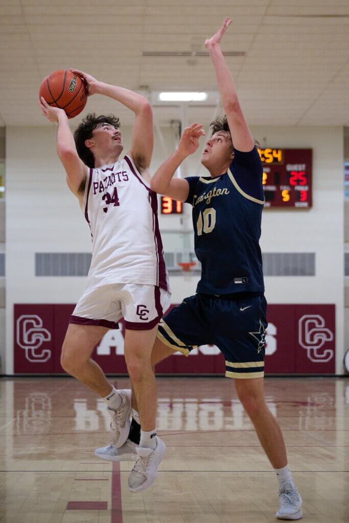 Patriots co-captain Zack Wynn shoots as Lexington’s Brendan Schwartz applies pressure. Photo by Jon Straggas
