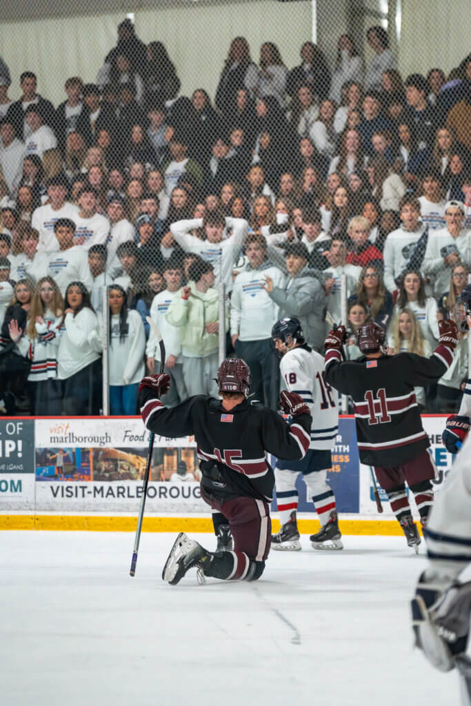 Acton-Carlisle captains senior Theo Price (center) and junior Joe Grasso (left) celebrate in front of the Lincoln-Sudbury student section after Price scores the second goal of the night. Photo by Aidan Moroney