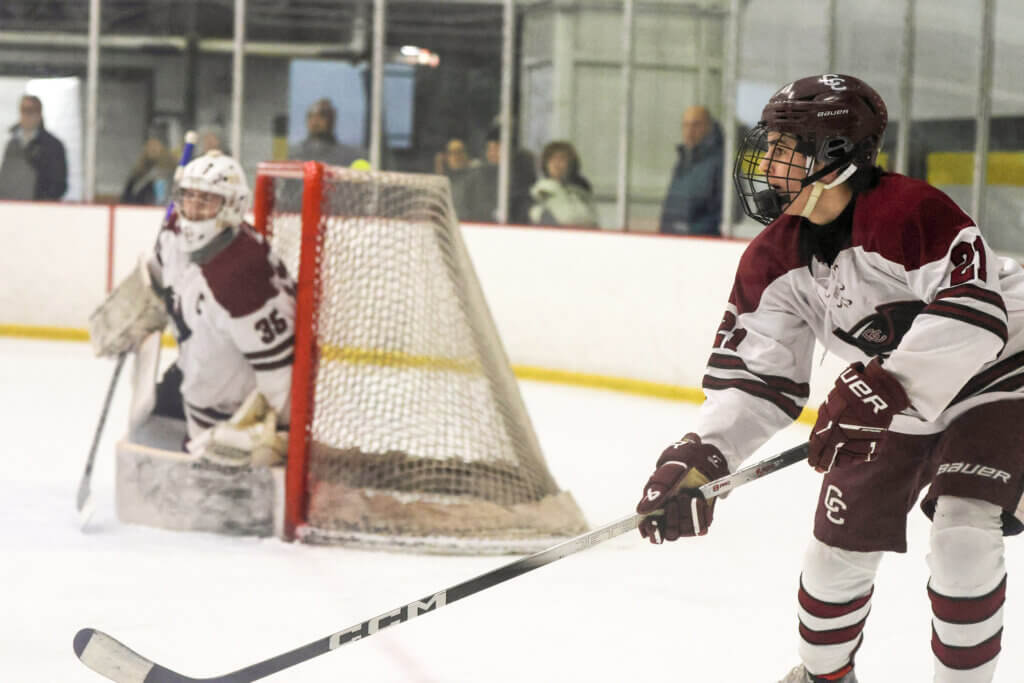 Patriots defenseman Fisher Tibbitt looks for an outlet pass opportunity, as goaltender Sam Griswold stays vigilant. Photo by Jennifer Kamionek