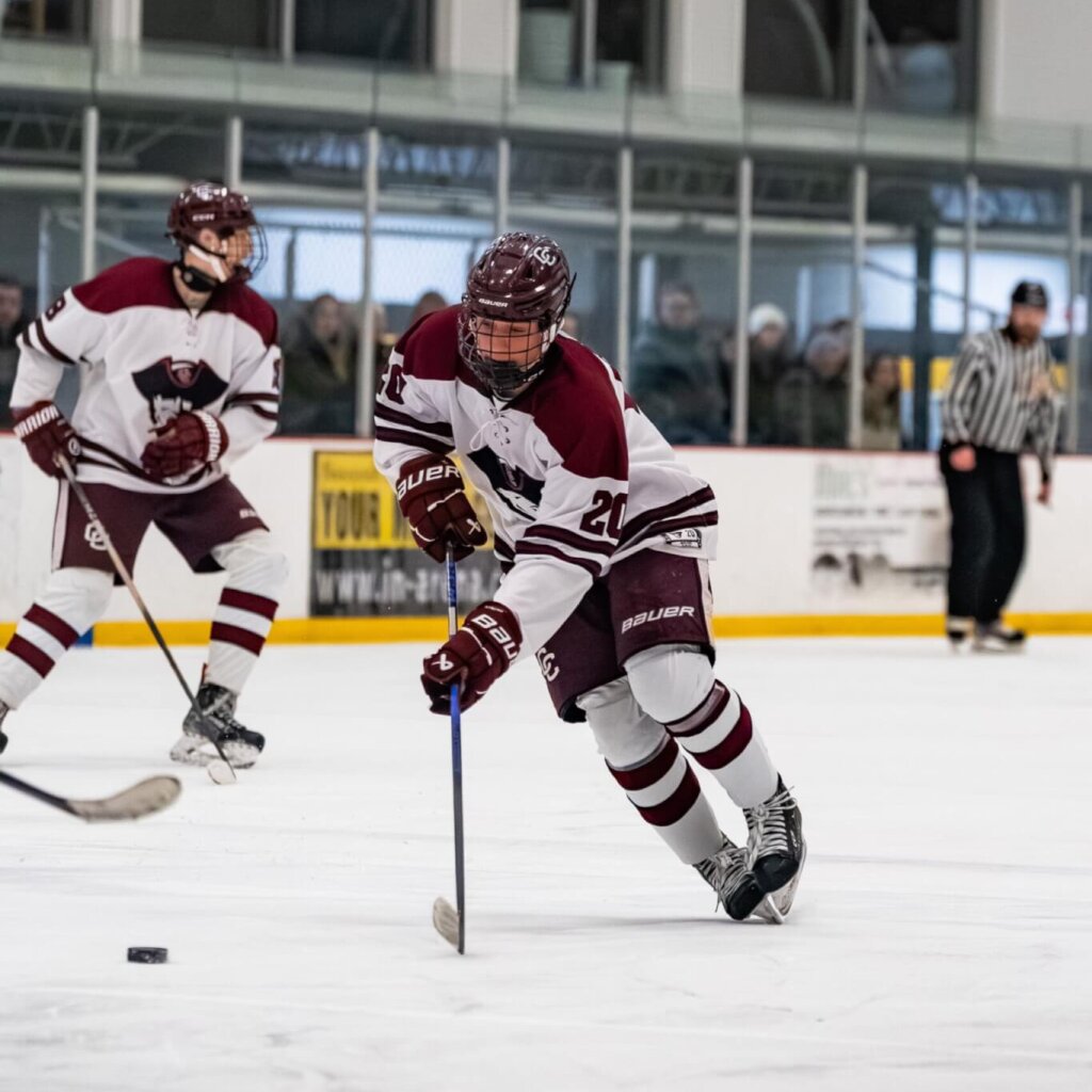 Acton-Carlisle junior Calvin Alexander strides for the puck during a home win against Boston Latin on February 14. Photo by Aidan Moroney