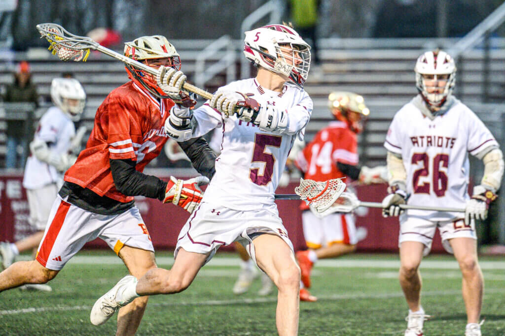 Acton-Carlisle co-captain John Anderson (No. 5) shoots and scores late in the fourth quarter of the Patriots’ April 2 game against visiting Bergen Catholic. Photos by Jon Straggas