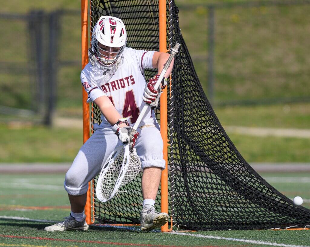 The Patriots’ Ben Wonsek (No. 14) defends the goal against Nashoba Regional on April 28. Photo by Jon Straggas
