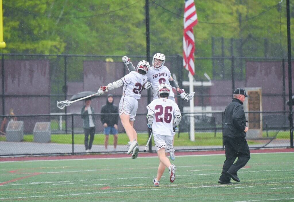 Tyler Shepard and James Reynolds celebrate after a Patriots goal against Acton-Boxborough on May 14. Photo by Henry Morgan