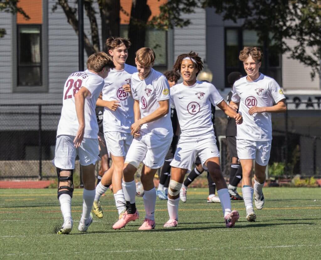 Cal van der Swaagh (No. 24) celebrates his goal with teammates Tyler Shepard (No. 28), Will McKenna (No. 25), Rory Best (No. 2), and Van Rowan (No. 20). Photo by Rebecca Woodward