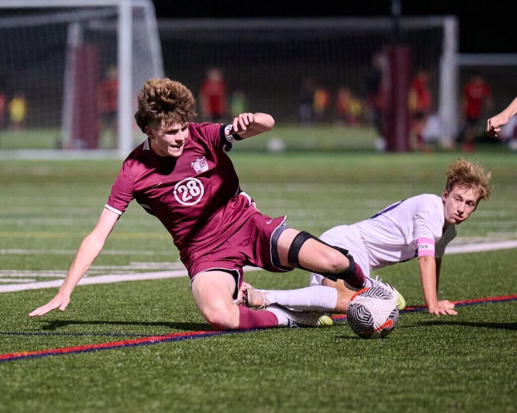 Tyler Shepard plays the ball against a Boston Latin defender. Photo by Jon Straggas