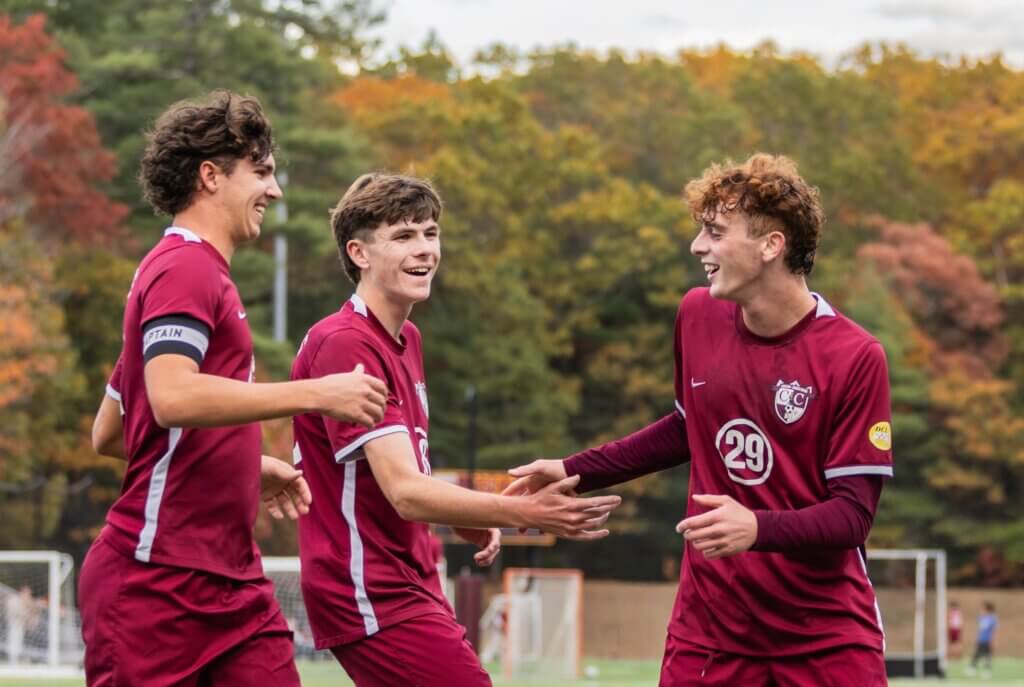 Cooper Balfour (No. 21), Tyler Shepard (No. 28), and Joe Ferrari (No. 29) celebrate a goal against Acton-Boxborough on October 23. Photo by Rebecca Woodward