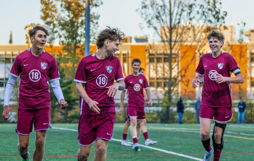 Max Hepworth (No. 18), Owen Tompsett (No. 19), Donovan Eaton (No. 17), and Tyler Shepard (No. 28) celebrating after Tompsett's goal against Waltham. Photo by Rebecca Woodward