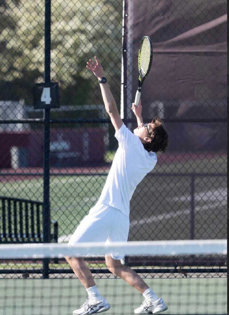 The Pats’ Adrien Guinebertiere serves against Waltham on May 1. Photo by Alexis Guinebertiere