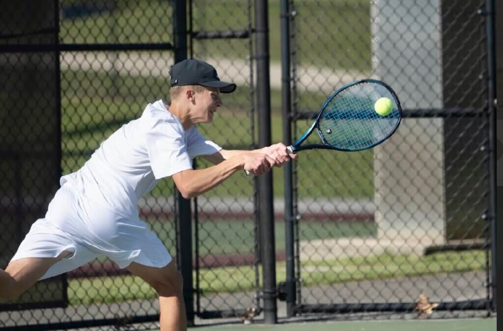 Acton-Carlisle’s Jack McClelland chases down the ball in his third singles match against Westford on May 12. Photo by Alexis Guinebertiere