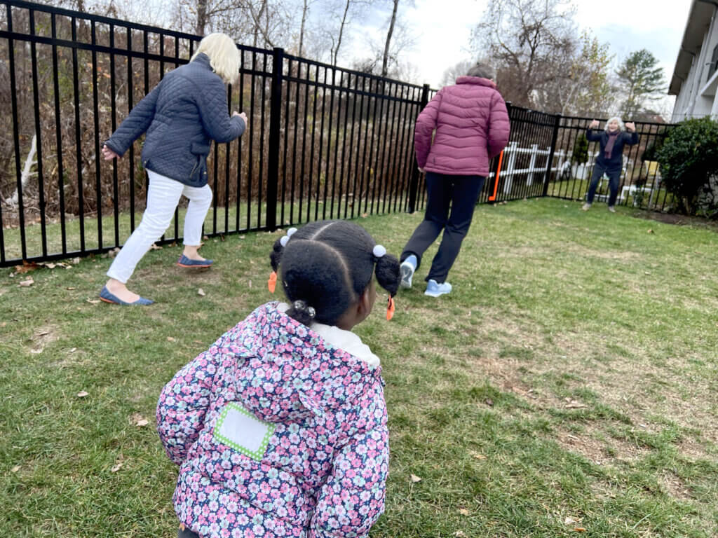A child plays "Red Light, Green Light" with volunteers in one of two new outdoor play spaces at the emergency shelter on Elm Street. Photo courtesy of Horizons for Homeless Children