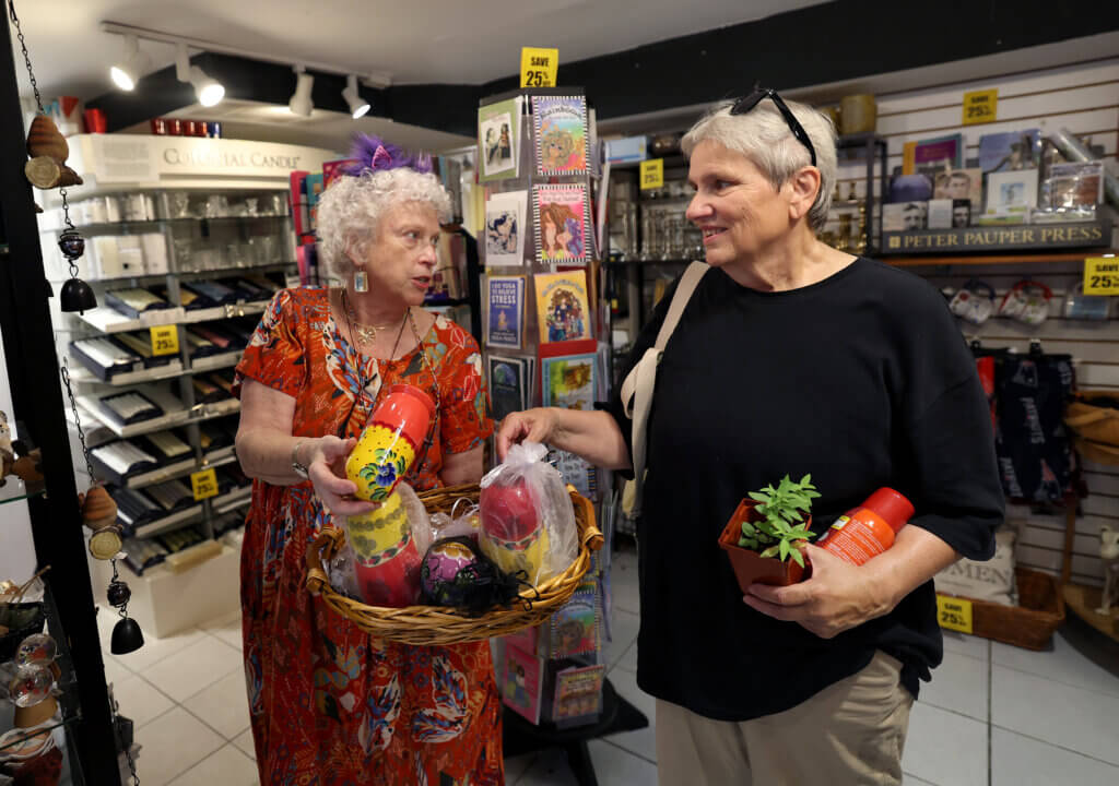 Marie Foley, owner of Revolutionary Acton on Main Street talks to customer Judith Frediani of Acton on Saturday, September 6, 2025 Foley is retiring and closing her “Shop heard ‘round the world.” Ken McGagh/The Acton Bridge