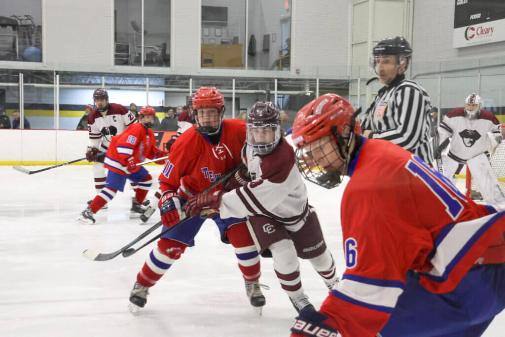 Senior Trevor Bailey fends off one player while going for the puck.