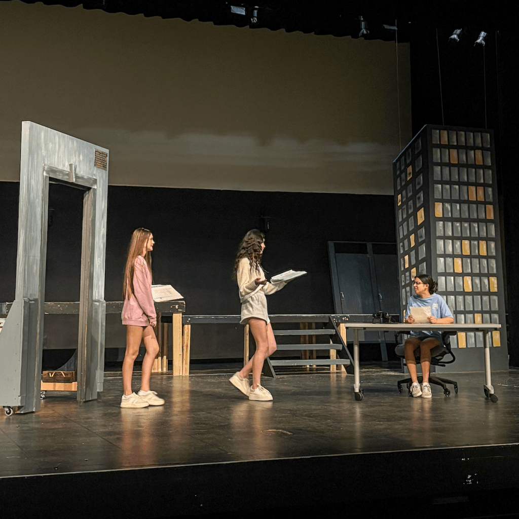 Judy (played by Nicole O'Reilly) and Doralee (Ari Hupe) tell Roz (Maya Soto) about a made-up work opportunity in France. Photo by Paloma Wigton