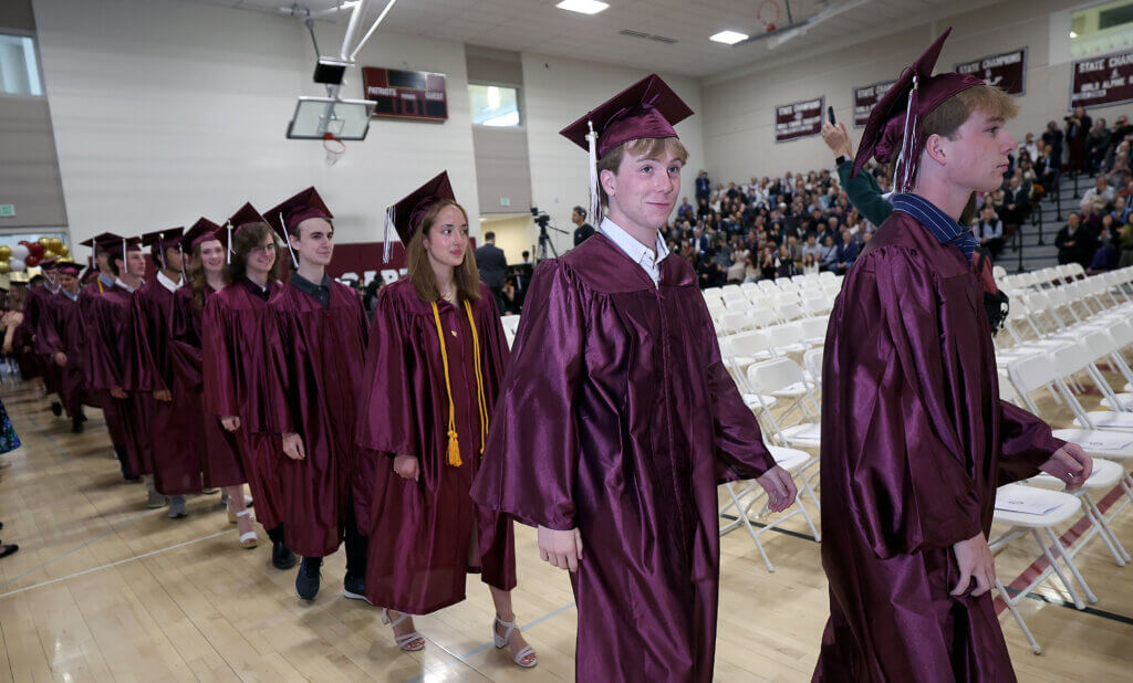 Graduating students file into the high school gymnasium.