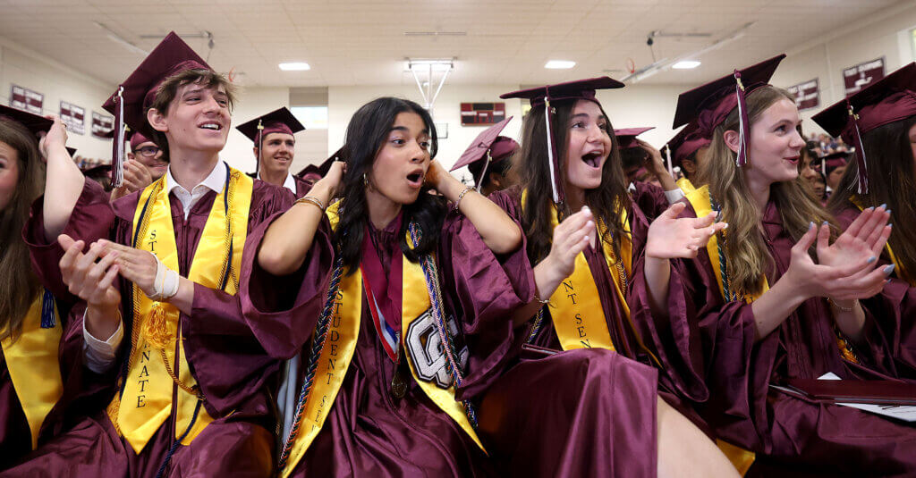 Excitement builds in the front row as the final graduate receives a diploma.