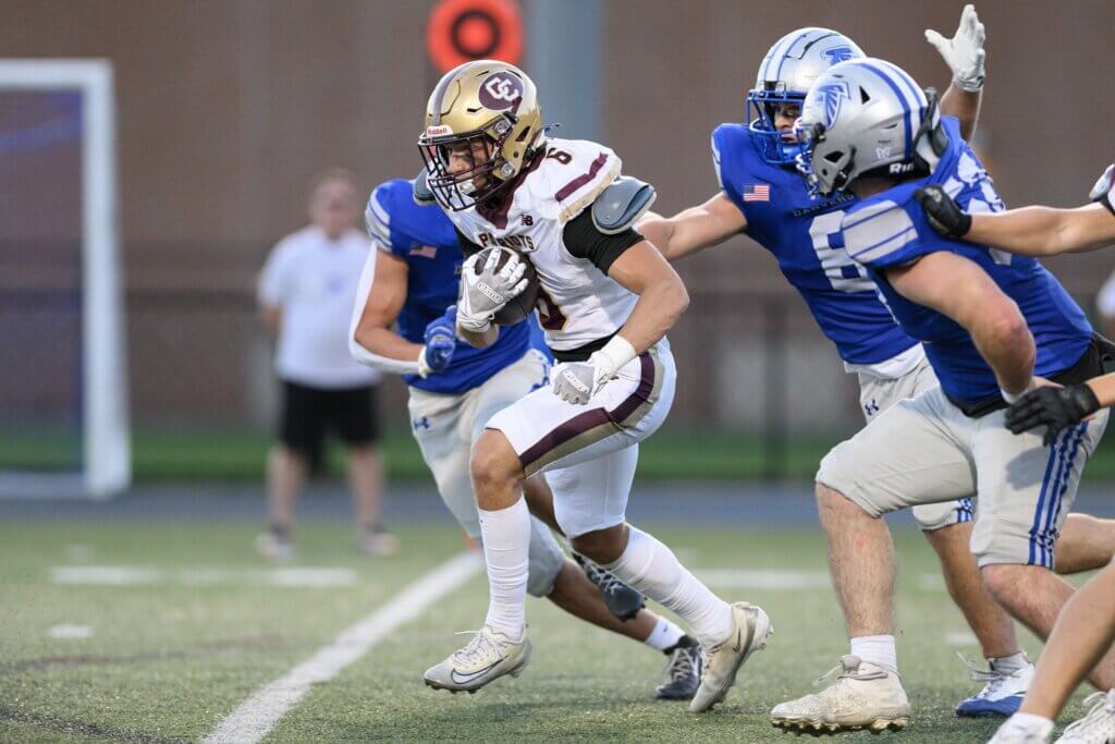 Acton-Carlisle co-captain Aiden Bayes breaks away from Danvers defenders in their clash on September 10. Photo by Jon Straggas