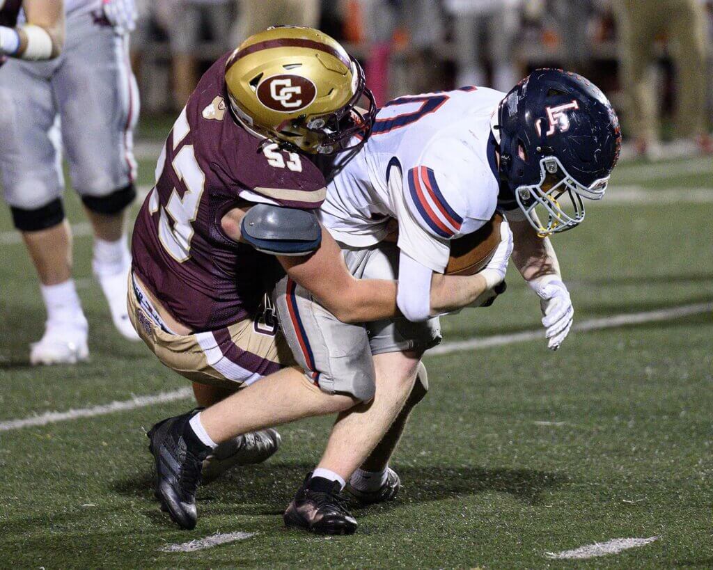 Co-captain Eric Nick tackles Lincoln-Sudbury running back Matthew Tasker (No. 10). Photo by Jon Straggas
