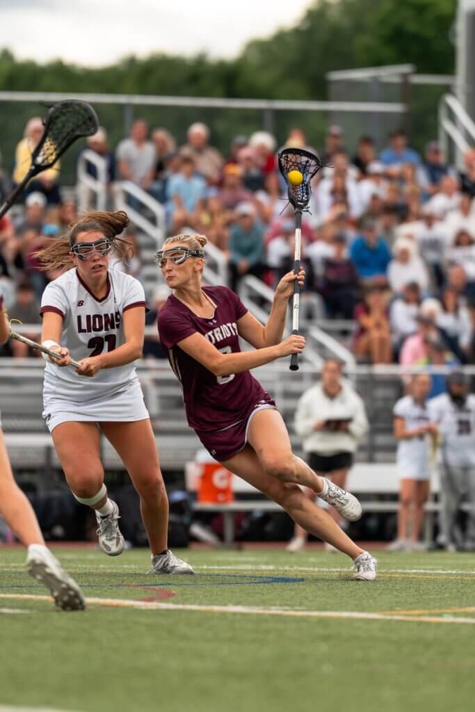 Patriots co-captain Sarah Fortier (center) celebrates after scoring the first goal of the second quarter to give CCHS a lead over Chelmsford. Photos by Aidan Moroney