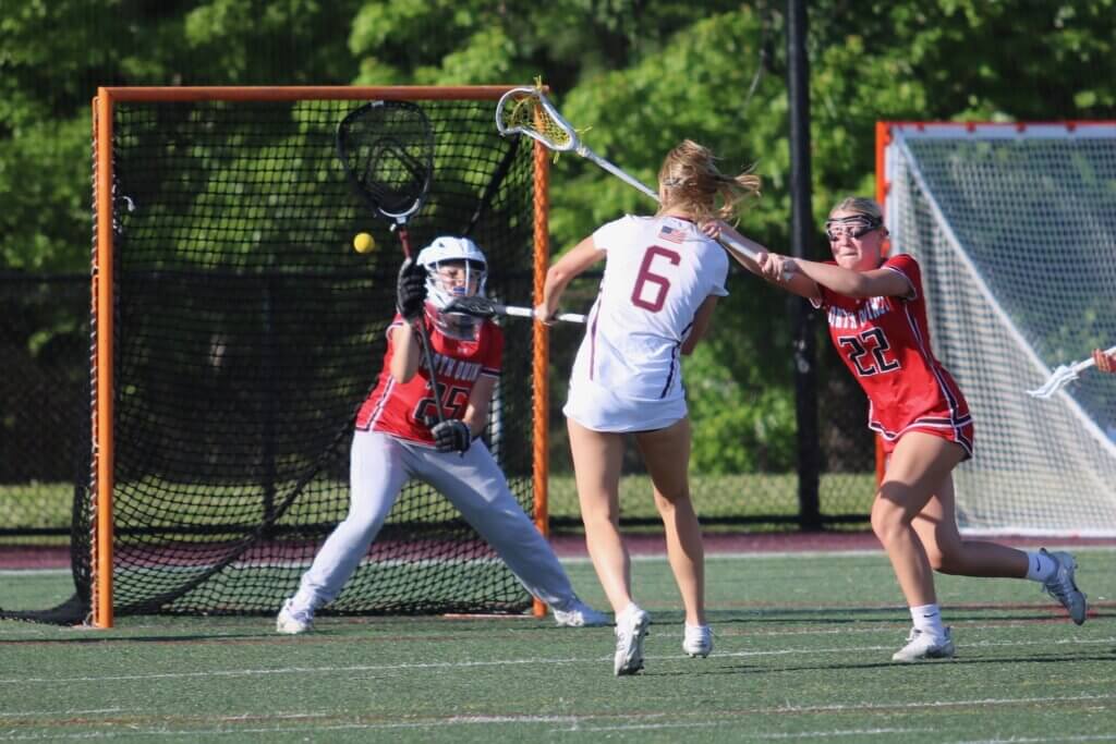 Scarlett Mirak finds the back of the North Quincy net, one of her six goals in the Patriots’ 19-7 rout on Wednesday. Photo by Bob Little
