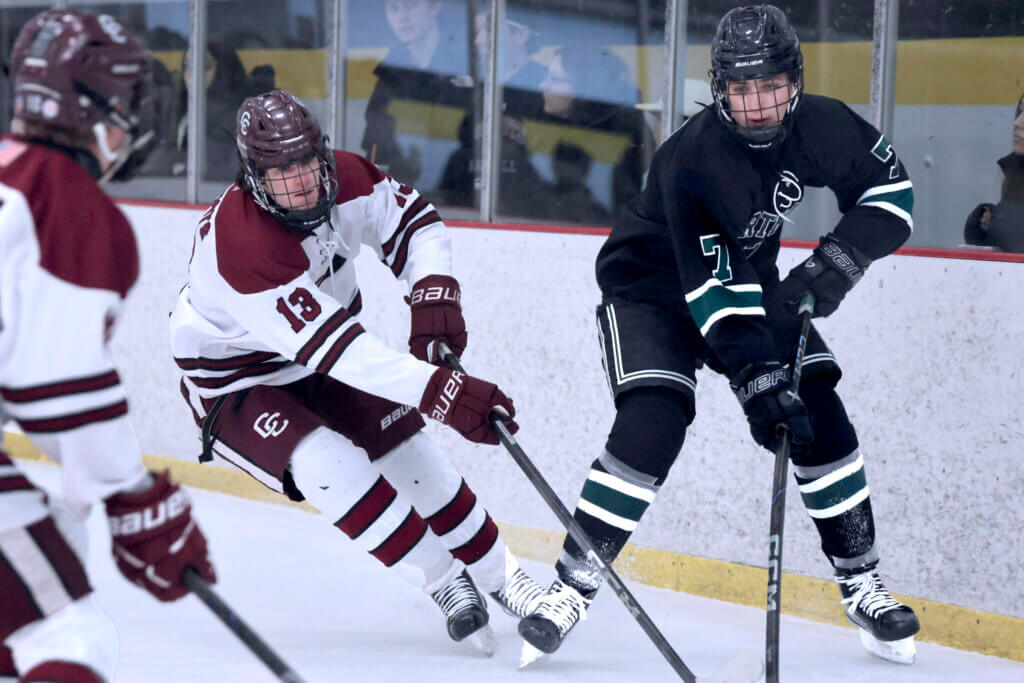 Junior Tommy Mckenna fights for the puck behind the CC net. Photo by Leslie Bailey