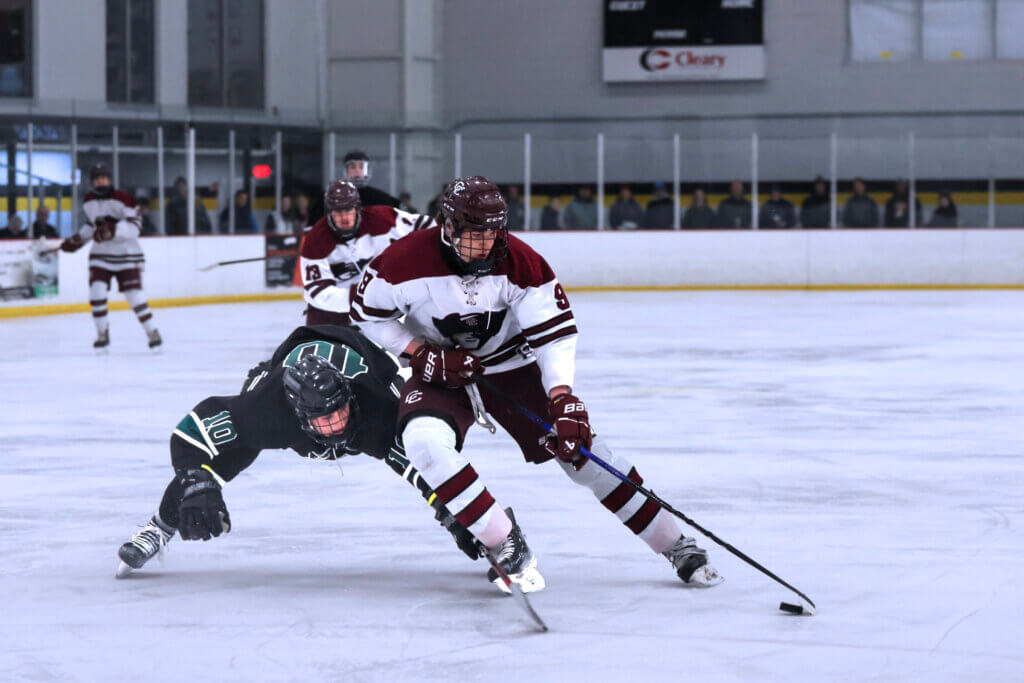 Junior Cam Doull fends off Dartmouth defender. Photo by Leslie Bailey
