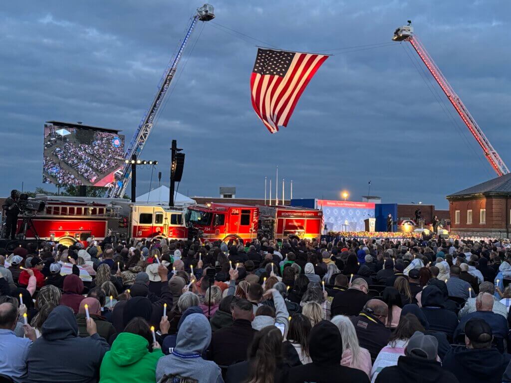 People in the crowd at the National Fallen Firefighters Memorial this past weekend held candles during a ceremony honoring those who lost their lives due to their work. Photo courtesy Acton Fire Department