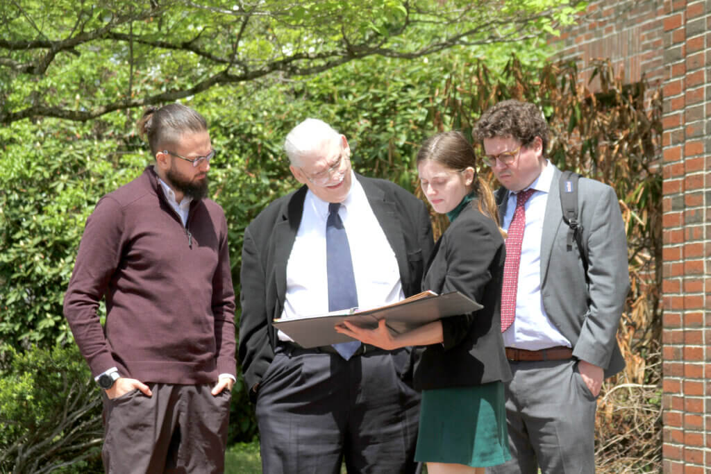 Brian Okum, left, reviews material with his legal team during a lunch break from his trial on May 13. Photo: Dakota Antelman/The Acton Bridge