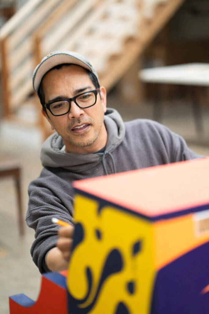Local artist Steve Bermundo sketches out lines for his geometric piano design. Photo by Evan Scales