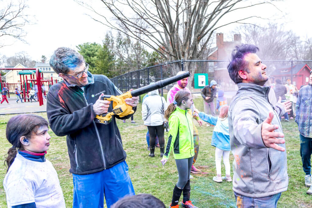 Matt Beaulac and Pankaj Arora add a little technology to the Holi festivities. Photo: Stephen Beyer/The Acton Bridge