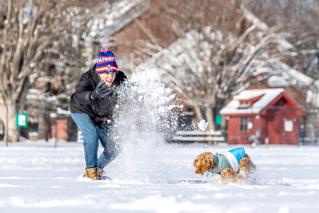 Tom Bird gives his dog, Norman, a little extra snowfall to chase at Emerson Field. Photo by Stephen Beyer